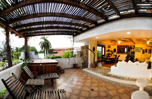 an outdoor living room with a wooden ceiling at Hotel Suites Ixtapa Plaza in Ixtapa