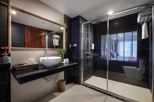 een badkamer met een wastafel en een glazen douche bij The View Sapa Hotel in Sa Pa