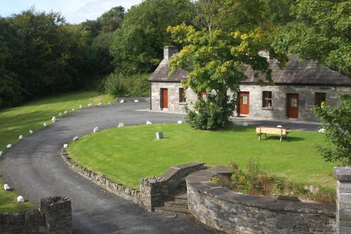 an old stone house with a bench in front of it at Falls Hotel & Spa in Ennistymon