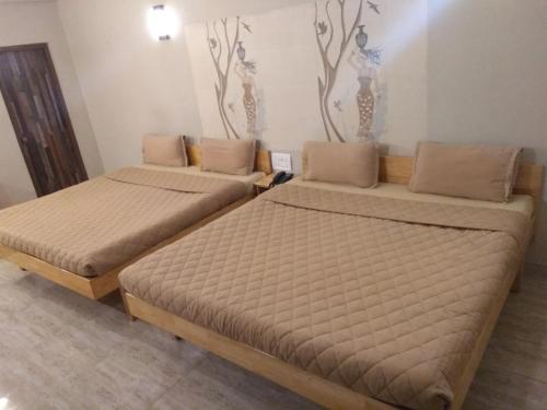 two beds sitting in a room withermottermottermott at Rathna Square in Pollāchi