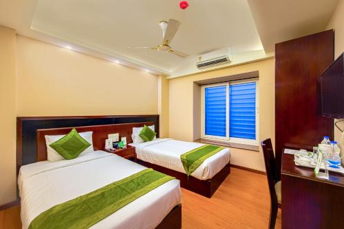 a hotel room with two beds and a window at Treebo Vedanta, Metropolitan in Kolkata