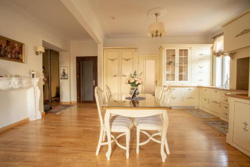 a kitchen with a wooden table and chairs at Broadway apartament in Šiauliai