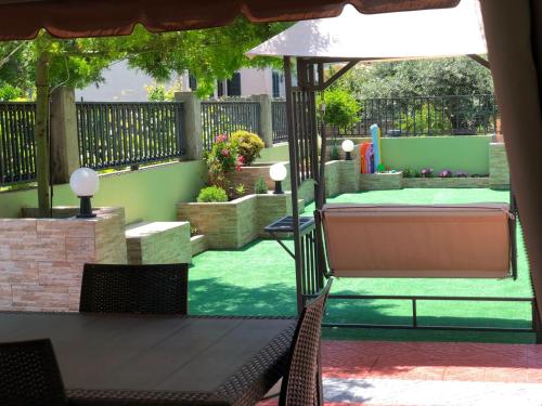 a patio with a table and chairs and an umbrella at La Dea Hestia in Bosa