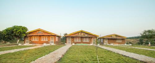 a row of houses in a field with grass at WOW STAYZ2 Pachmarhi Foothill Cottages in Pachmarhī