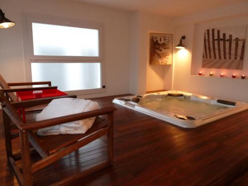 a room with a hot tub and a table and chairs at La Villa en L'île - 2 Piscines & Spa in Noirmoutier-en-l'lle