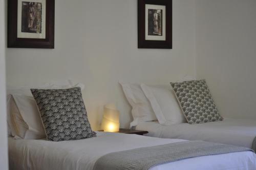 two beds sitting next to each other in a room at Wildekrans Country House in Botrivier