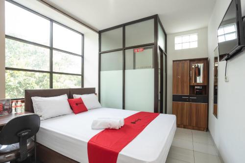 a bedroom with a bed with a red blanket on it at RedDoorz near Eka Hospital BSD City in Tangerang