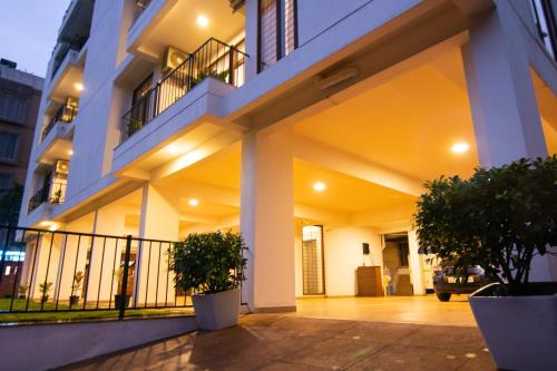 an apartment building with two potted trees in front of it at Stay@ in Bangalore