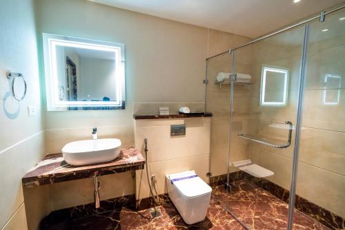 Un baño con lavabo, ducha e inodoro. en JK HOTELS, en Coimbatore