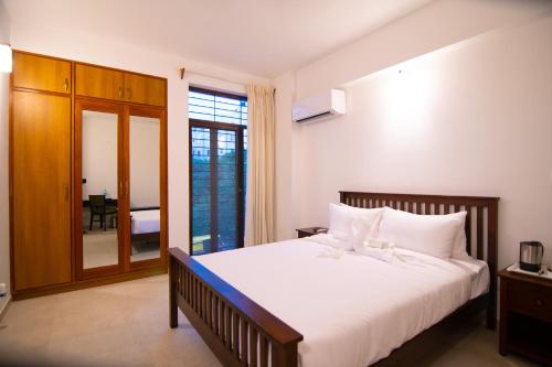 a bedroom with a large white bed and a window at Stay@ in Bangalore