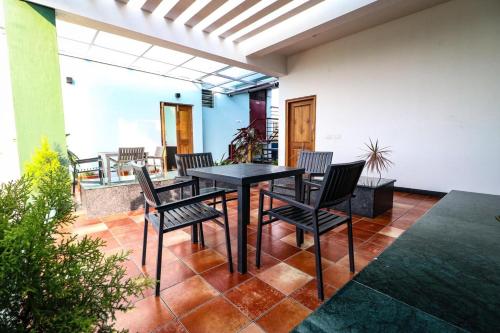patio z czarnym stołem i krzesłami w obiekcie Osho Glimpse Mysore w mieście Mysuru