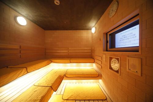 a sauna with two beds and a flat screen tv at Dormy Inn Premium Osaka Kitahama in Osaka