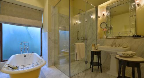 a bathroom with a tub and a sink and a shower at Taj Nadesar Palace in Varanasi