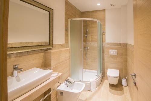 a bathroom with a shower and a sink and a toilet at Hotel Quercus in Međugorje