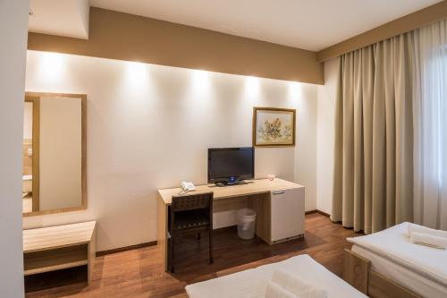 a hotel room with a desk with a television on it at Hotel Quercus in Međugorje