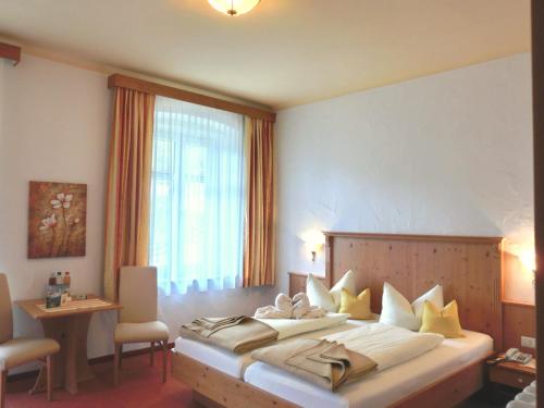 a hotel room with a large bed and a window at Hotel-Garni Drachenburg in Mittenwald
