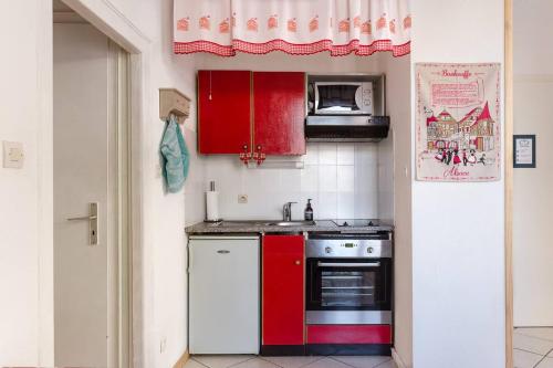 Il comprend une cuisine équipée d'une cuisinière rouge et d'un four micro-ondes. dans l'établissement Travel Homes - The Bredele, next to Little Venice, à Colmar