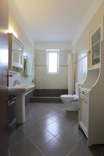 SkroponeriaにあるVilla Skroponeriaのバスルーム(洗面台、トイレ付)、窓が備わります。