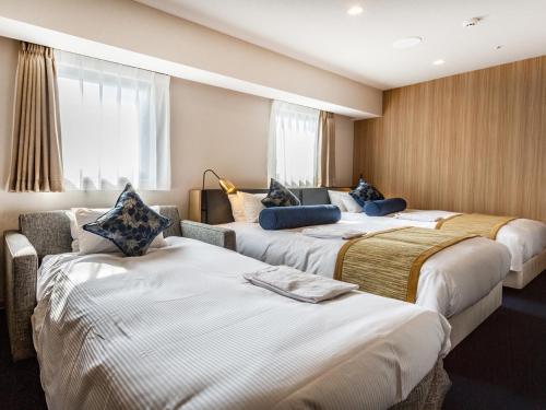 a hotel room with three beds in it at Meitetsu Inn Nagoya Kanayama Annex in Nagoya