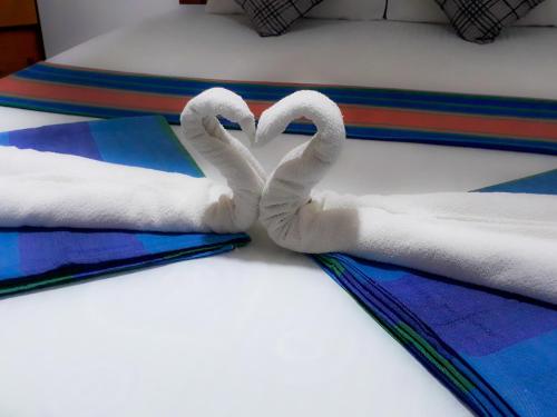 two towelsrendered to look like swans sitting on a bed at Danara Homestay in Sigiriya