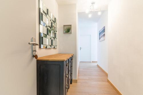 einen Flur mit einem Tisch in einem Zimmer in der Unterkunft Madame Vacances Les Palmiers du Golf Service Premium in Moliets-et-Maa