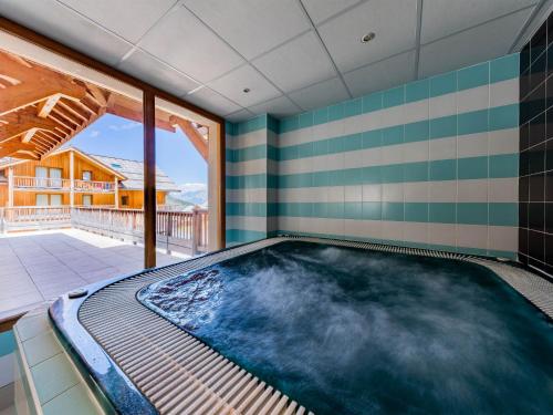 - une piscine intérieure dans une pièce dotée d'une grande fenêtre dans l'établissement SUNWEB Chalets de Bois Méan, aux Orres