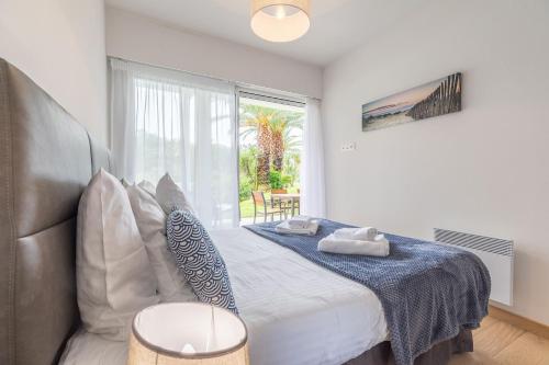 - une chambre avec un lit et une grande fenêtre dans l'établissement Madame Vacances Les Palmiers du Golf Service Premium, à Moliets-et-Maa