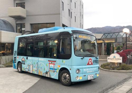 a blue bus parked in front of a building at Fujisan Station Hotel in Fujiyoshida