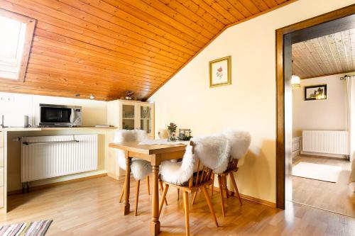 una cucina e una sala da pranzo con soffitto in legno di Ferienwohnung Haus Lehen a Sankt Koloman