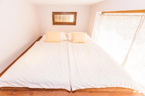 a bed with two pillows in a room with a window at Villa Nabucco in Kras