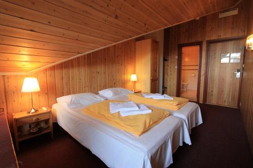 a bedroom with a large bed with towels on it at Fanitullen Apartments in Hemsedal