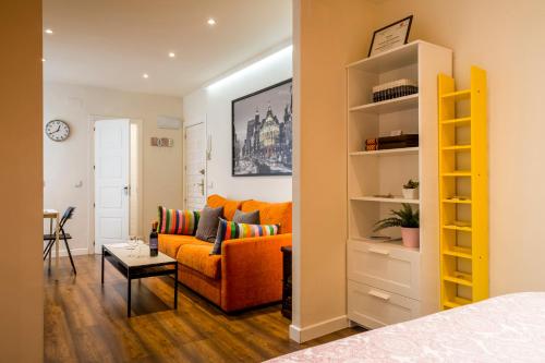 Barbieri في مدريد: غرفة معيشة مع أريكة برتقالية وطاولة