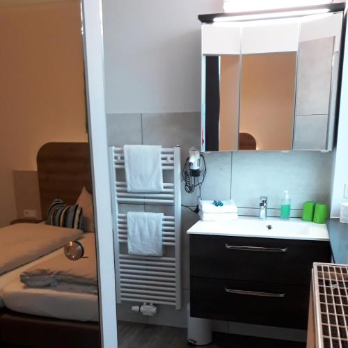 a small bathroom with a sink and a mirror at Hotel M24 - Alle Zimmer mit Küchenzeile & Self-CheckIn in Vechta