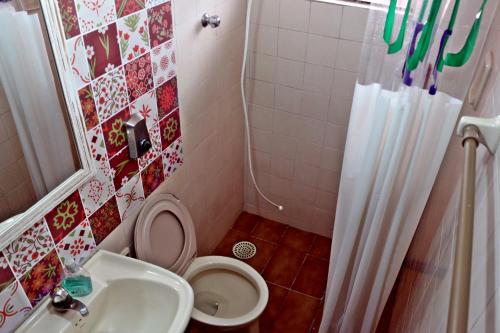 Un baño pequeño con inodoro y lavabo. en KR Hostel Ilhabela, en Ilhabela