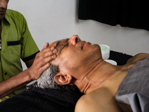 a man getting his face examined by a doctor at Plantation Villa in Kalutara