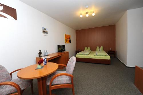 um quarto de hotel com uma cama, uma mesa e cadeiras em Gasthof und Pension Zick em Eggesin