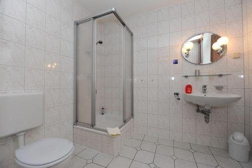 uma casa de banho com um chuveiro, um WC e um lavatório. em Gasthof und Pension Zick em Eggesin