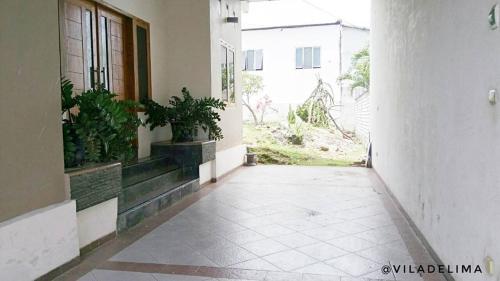 an empty hallway of a building with potted plants at Vila Delima in Lamongan