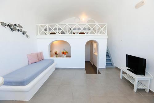 a living room with a couch and a tv at Ilioperato Hotel in Imerovigli