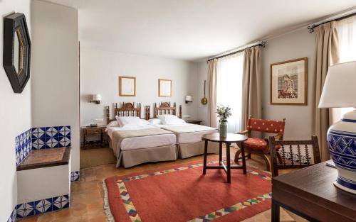 Habitación de hotel con 2 camas y mesa en Parador de Arcos de la Frontera en Arcos de la Frontera