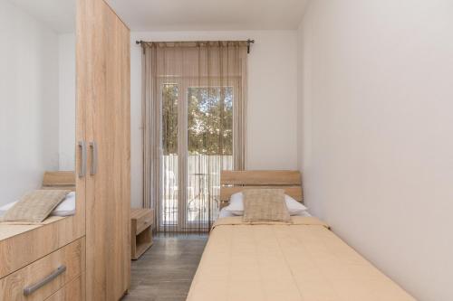 a bedroom with two beds and a window at Pasko 4 modern furnished ap for 7 in Novalja
