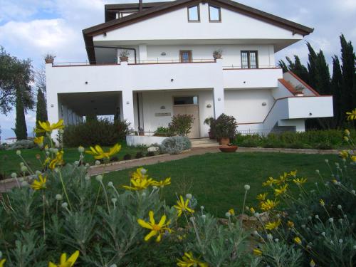 a white house with a yard with yellow flowers at B&B Radici24 in Battipaglia