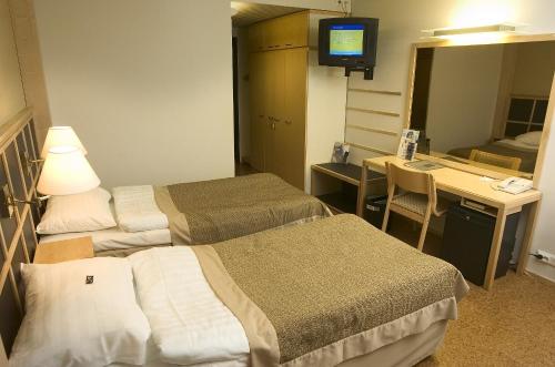 a hospital room with two beds and a desk at Finlandia Hotel Imatran Kylpylä Spa in Imatra