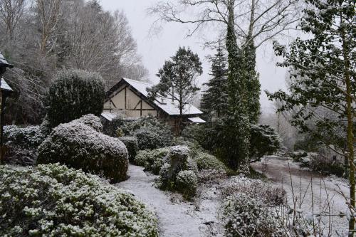 a garden covered in snow in front of a house at Llethrau Forest & Nature Retreats in Knighton