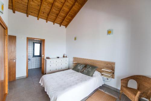 a bedroom with a bed with a wooden headboard at Casa do Nuno T2 in Canto