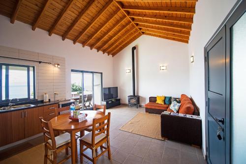 eine Küche und ein Wohnzimmer mit einem Tisch und einem Sofa in der Unterkunft Casa do Nuno T2 in Canto