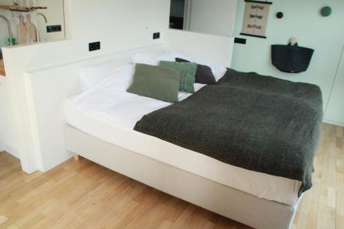 a large white bed with a gray blanket on it at Houseboat Studio Sooki in Amsterdam