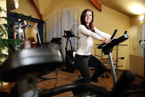 a woman is standing in a gym at Orchidea Hotel Lipót in Lipót