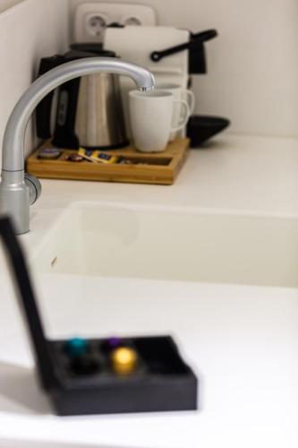 a kitchen counter with a sink with a coffee maker at Neratze Hammam Suites in Rethymno Town