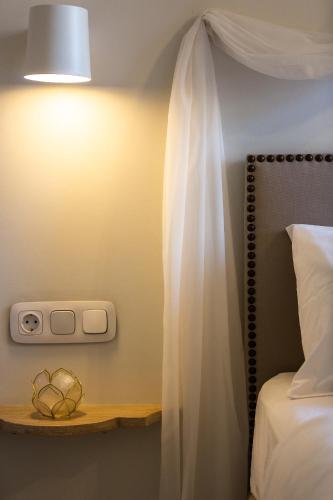 a bedroom with a bed and a light on a wall at Neratze Hammam Suites in Rethymno Town